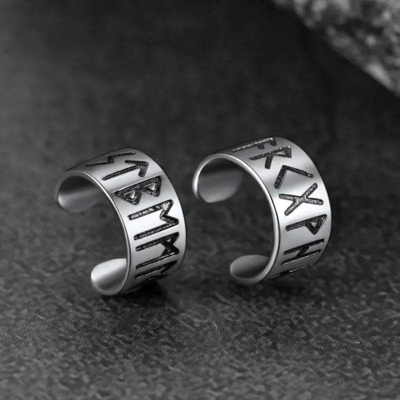 Two silver rune-inscribed ear cuffs.