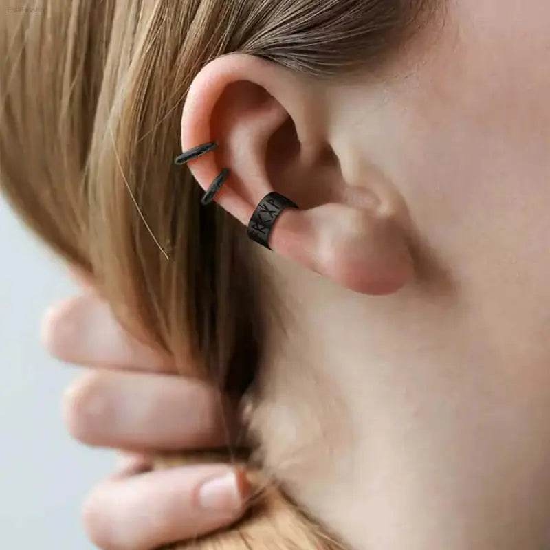 Ear with black cuff earrings.
