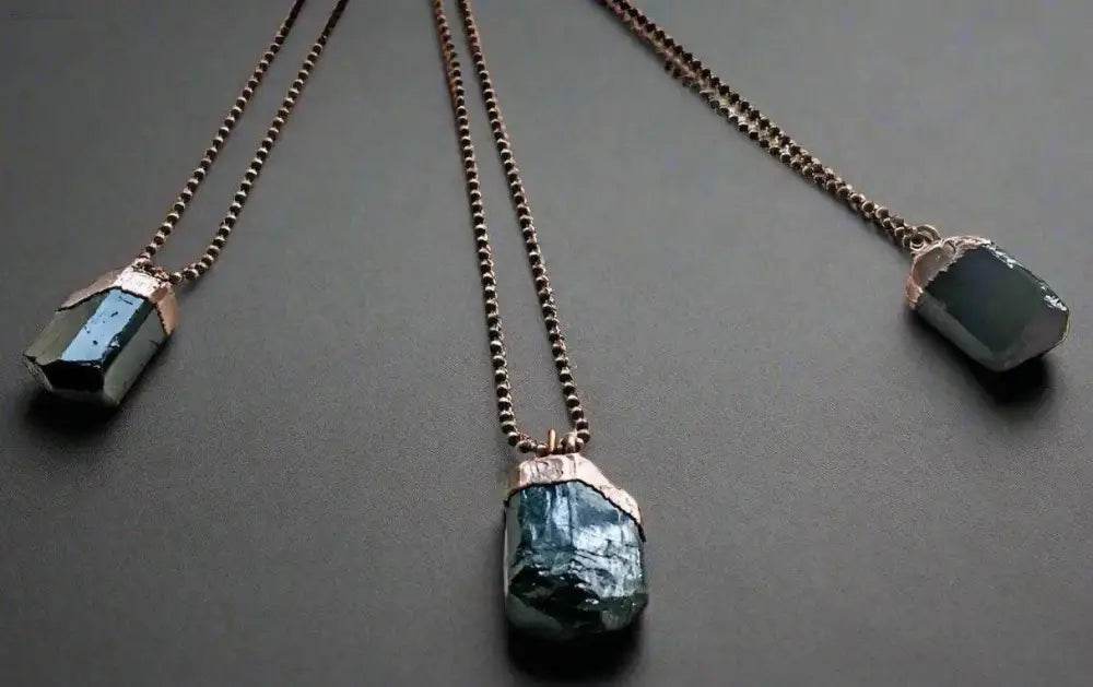 Three crystal pendant necklaces.