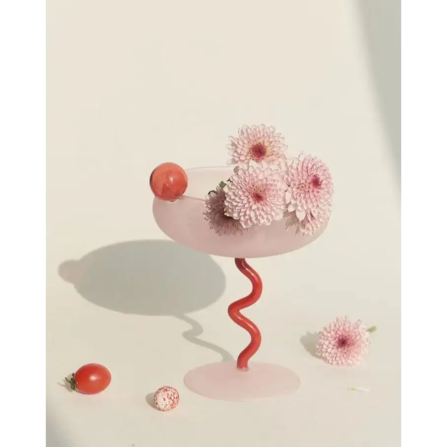 Pink glass with red spiral stem and flowers for a whimsical eclectic dopamine cocktail