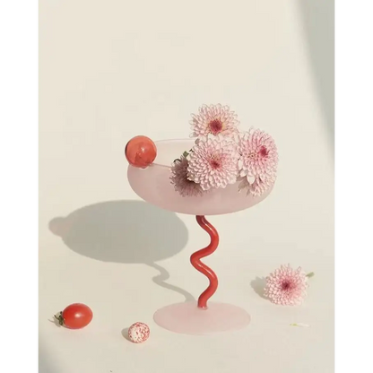 Pink glass with red spiral stem and flowers for a whimsical eclectic dopamine cocktail