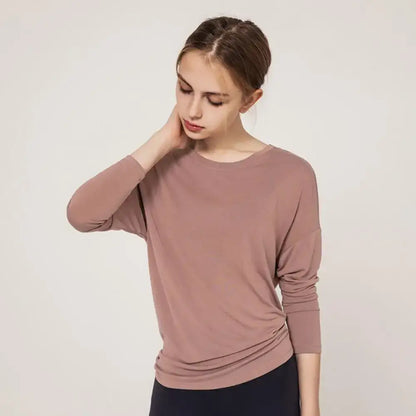 Woman in a mauve long-sleeved shirt styled for fast dry running and loose yoga clothes