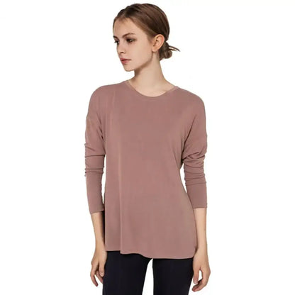 Woman in a long-sleeved mauve top, perfect for fast dry running or yoga classes